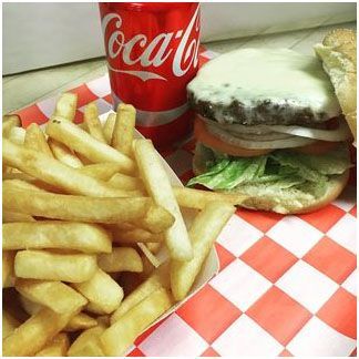 A cheeseburger and French fries next to a coca cola can