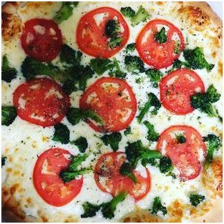 A White pizza with broccoli and tomato on it