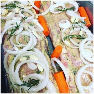 Pork loins covered in onions and carrots ready to be cooked