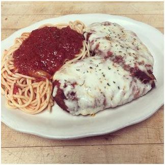 A white plate topped with spaghetti and meatballs on a wooden table