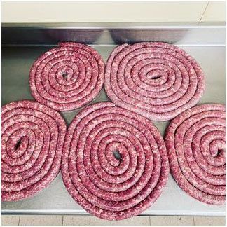 Homemade sausage sitting on top of a stainless steel table