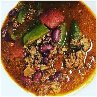 A close up of a bowl of homemade chili with meat and beans