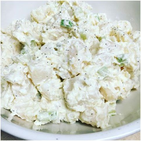 A close up of a bowl of potato salad on a table