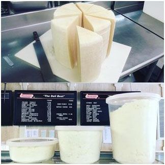 A large piece of Pecorino Romano cheese is sitting on top of a cutting board