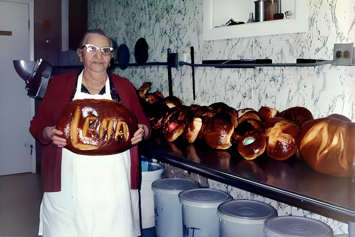 A picture of an elderly lina pizza holding a large loaf of bread