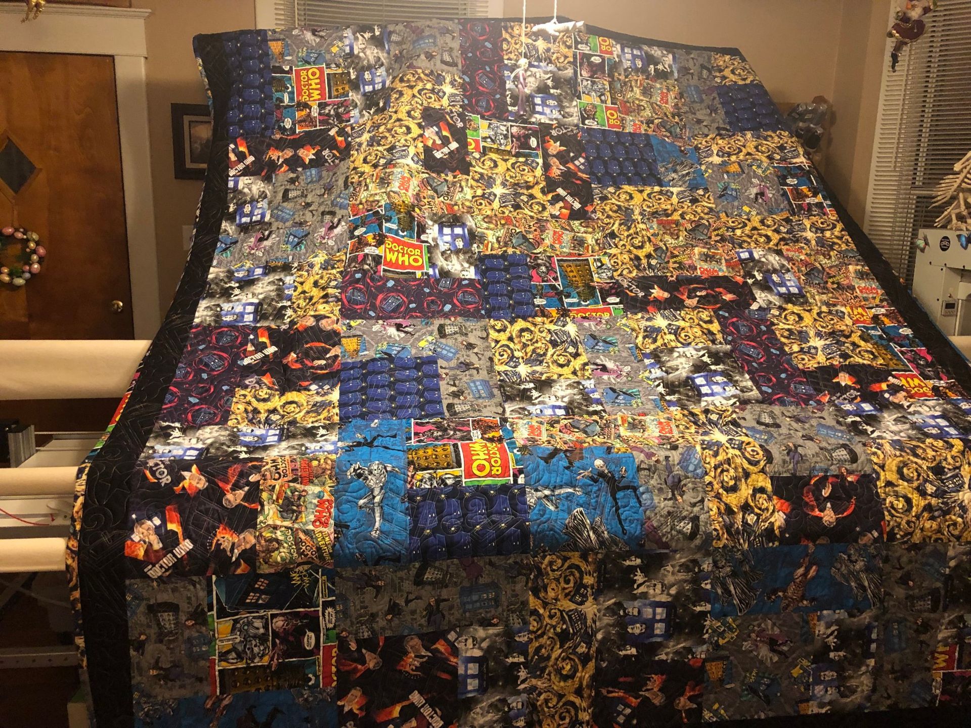 Quilted bedspread with colorful patterned fabric draped over a bed in a bedroom