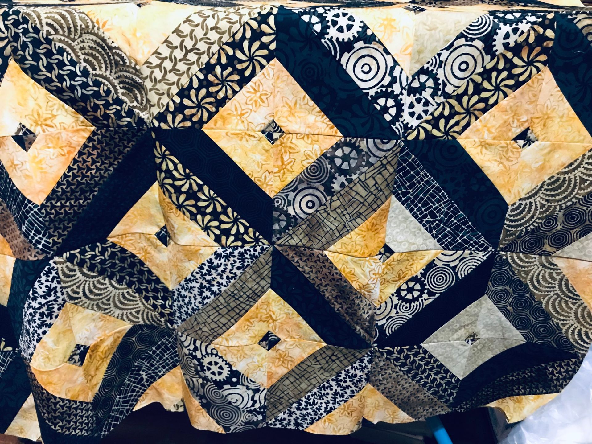 Blue, gold, and cream patchwork quilt with geometric diamond and floral patterns