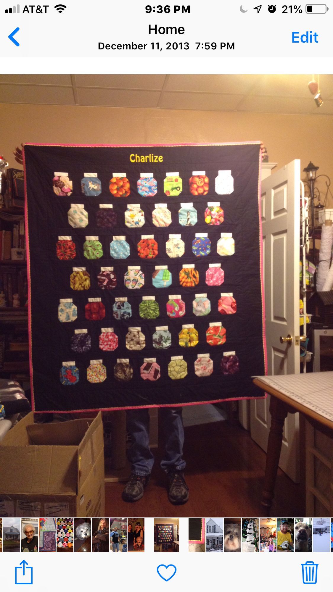 Person holding a black quilt covered with colorful owl patches indoors