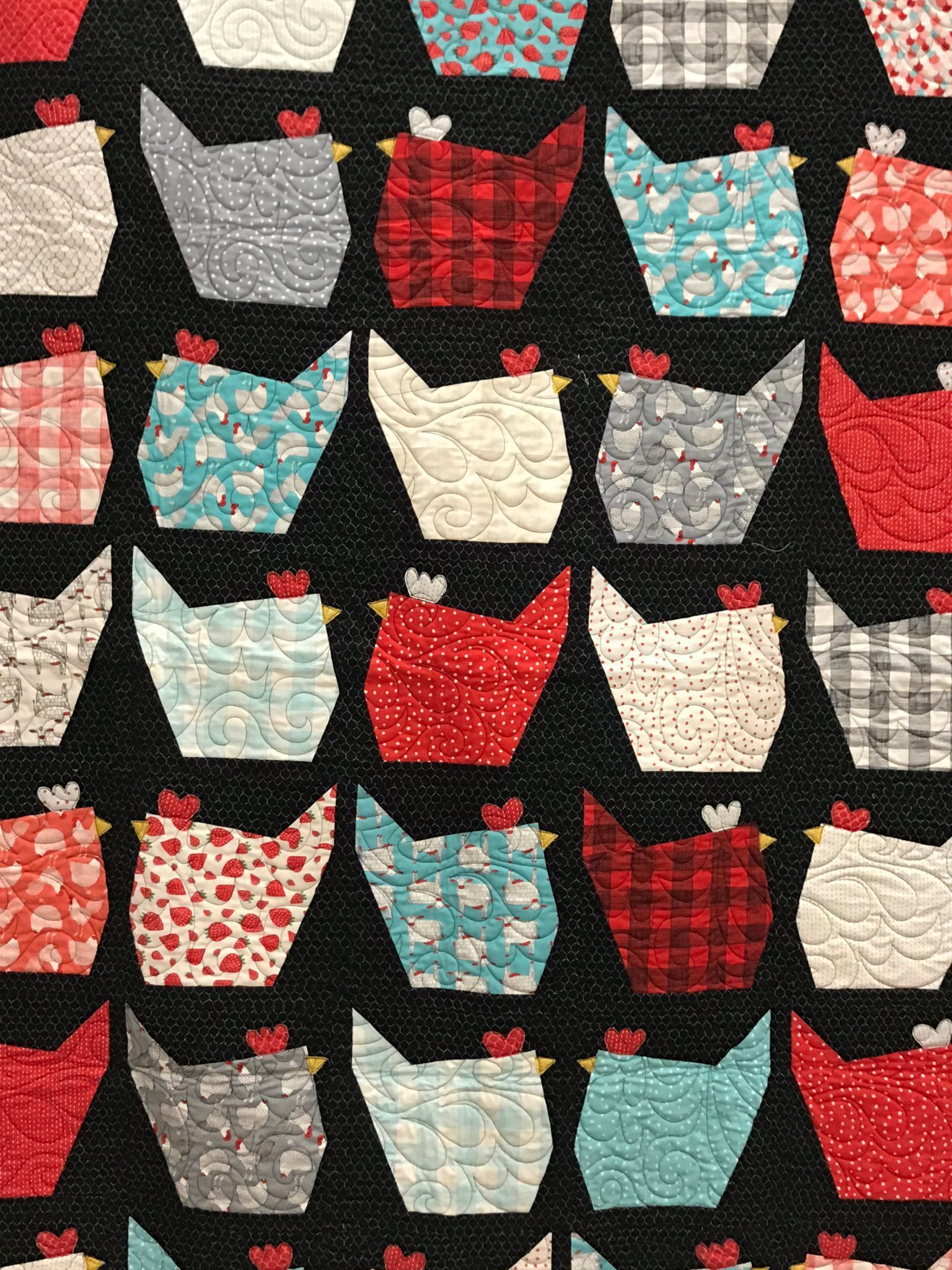 Rows of colorful patterned tote bags hanging against a black background