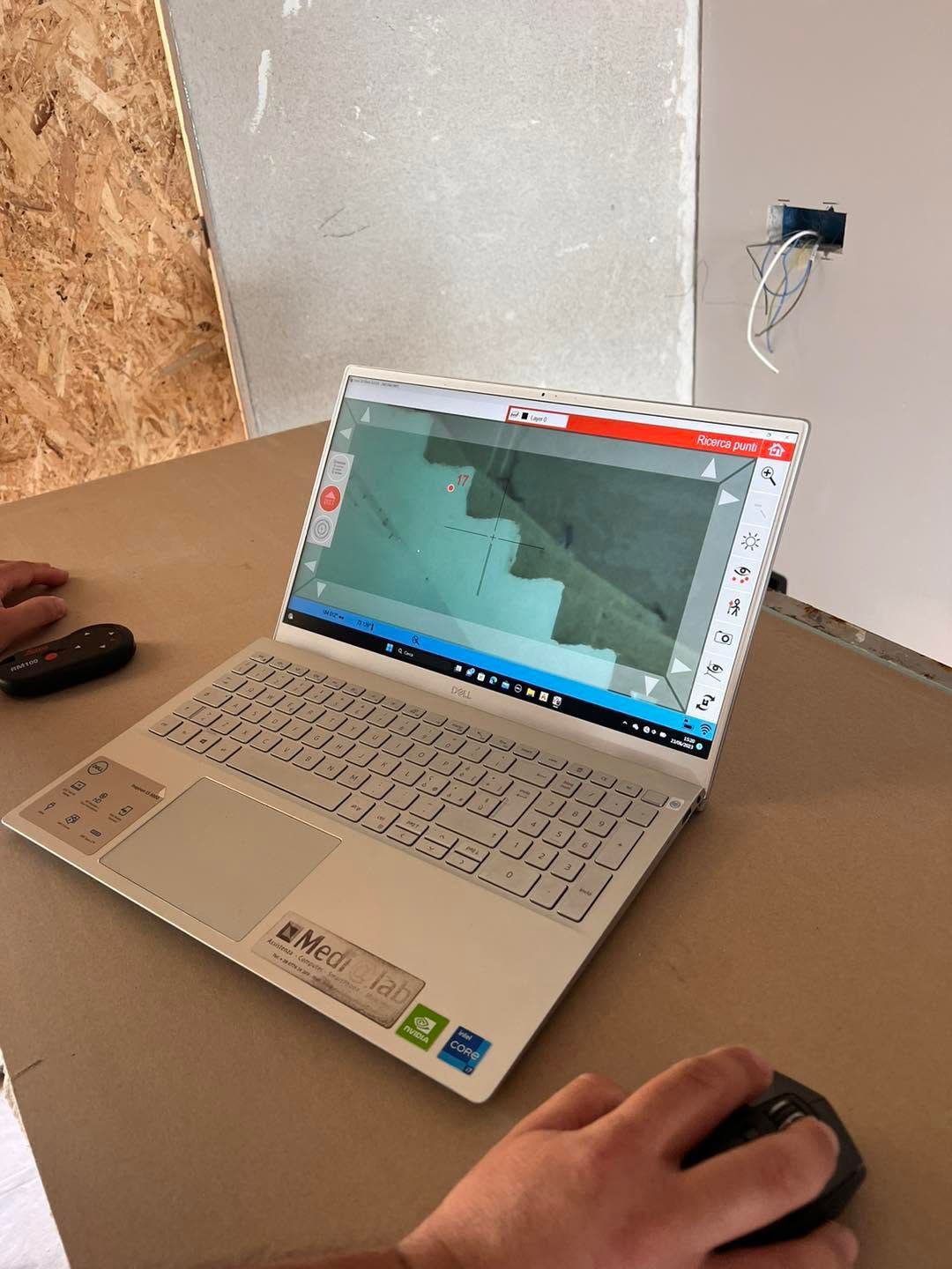 Un computer portatile su un tavolo da lavoro mostra il progetto di una scala, mentre una mano usa il mouse nelle vicinanze.
