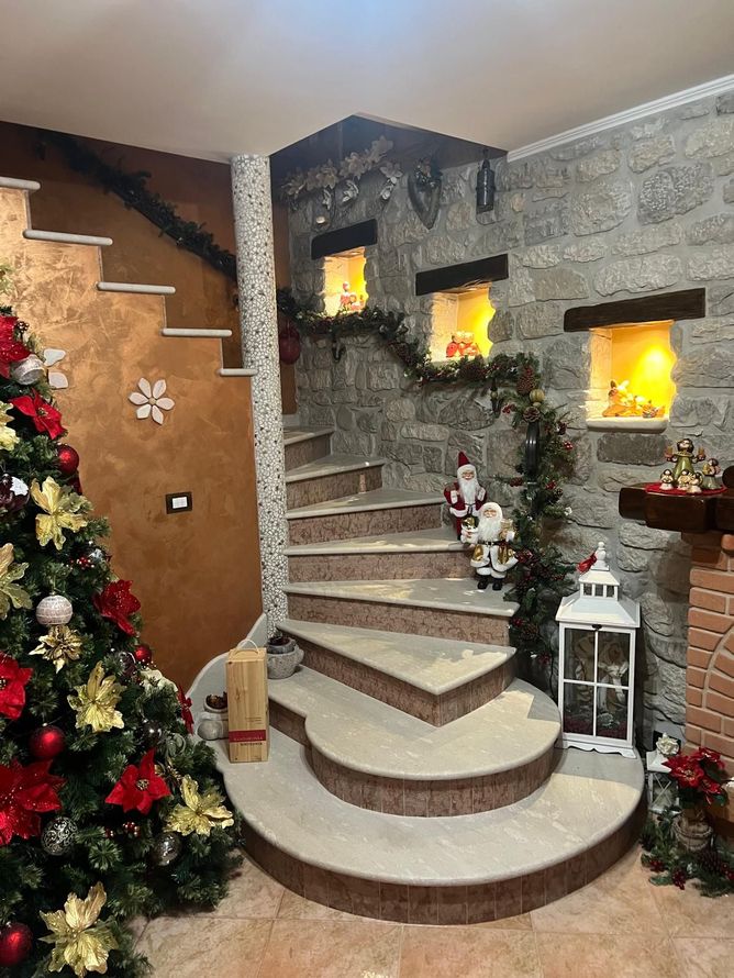 Scala interna festiva con albero di Natale, ghirlande, candele e calde nicchie a muro