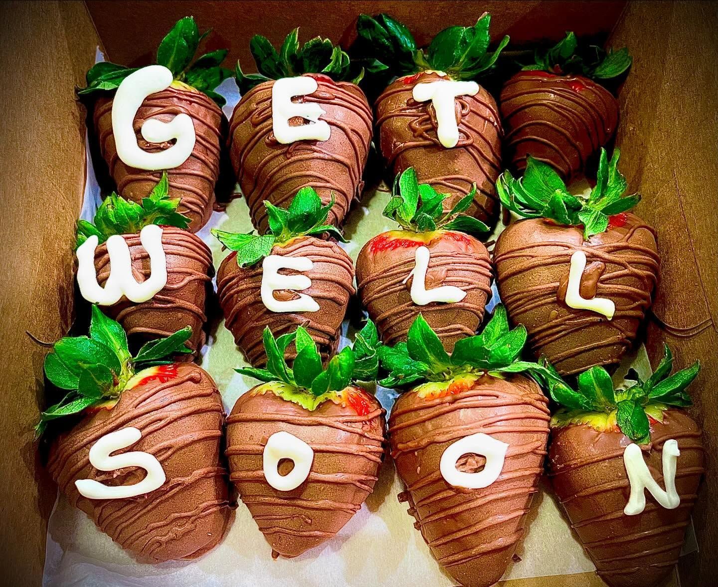 Chocolate strawberries arranged to spell “GET WELL SOON” on a tray