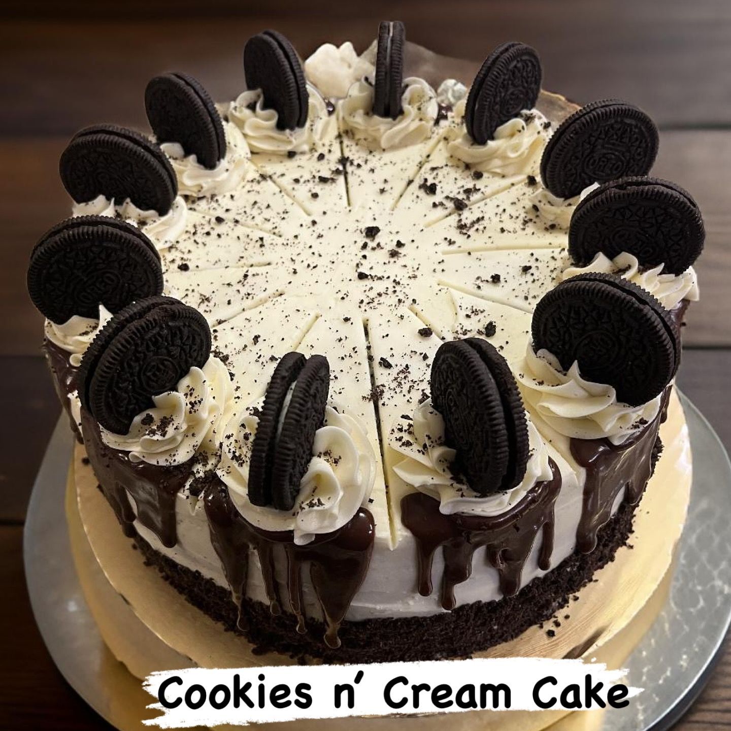 Cookies and cream cake topped with Oreo cookies and chocolate drizzle