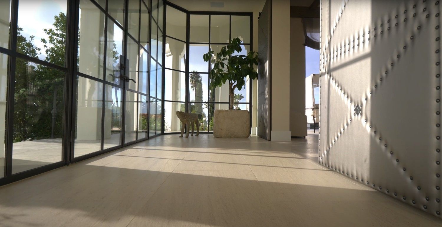 A hallway with a lot of windows and a plant in the middle.