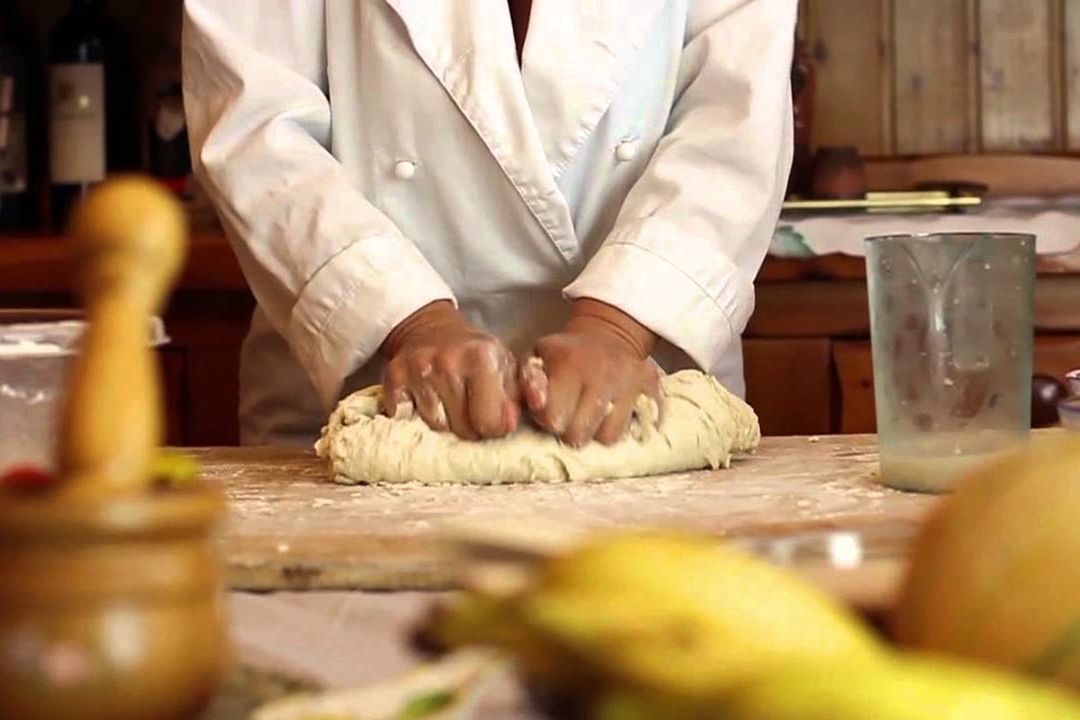 Cuoco in cucina che impasta