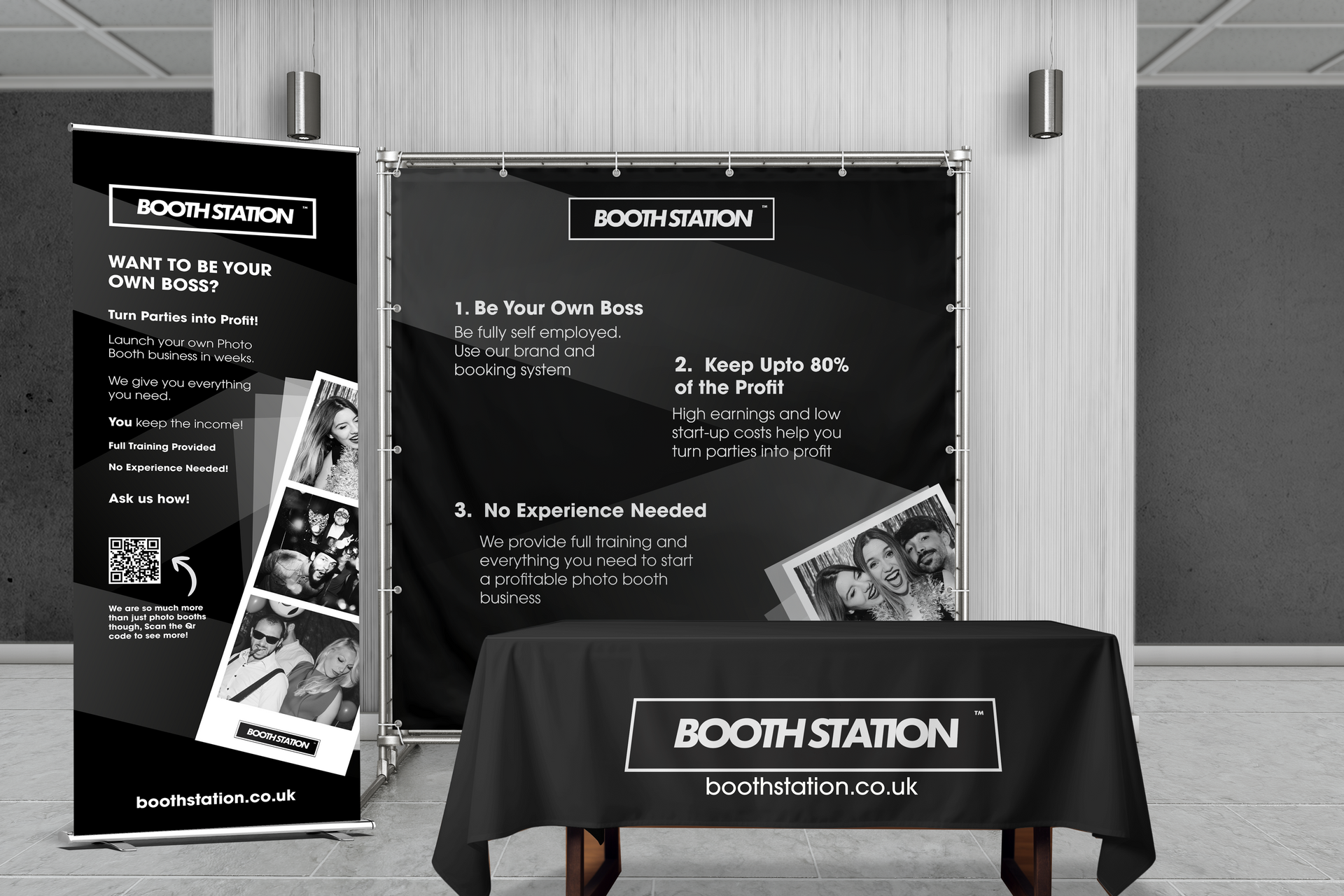 A trade show booth display featuring a black backdrop, a banner, and a branded table cloth all labeled 