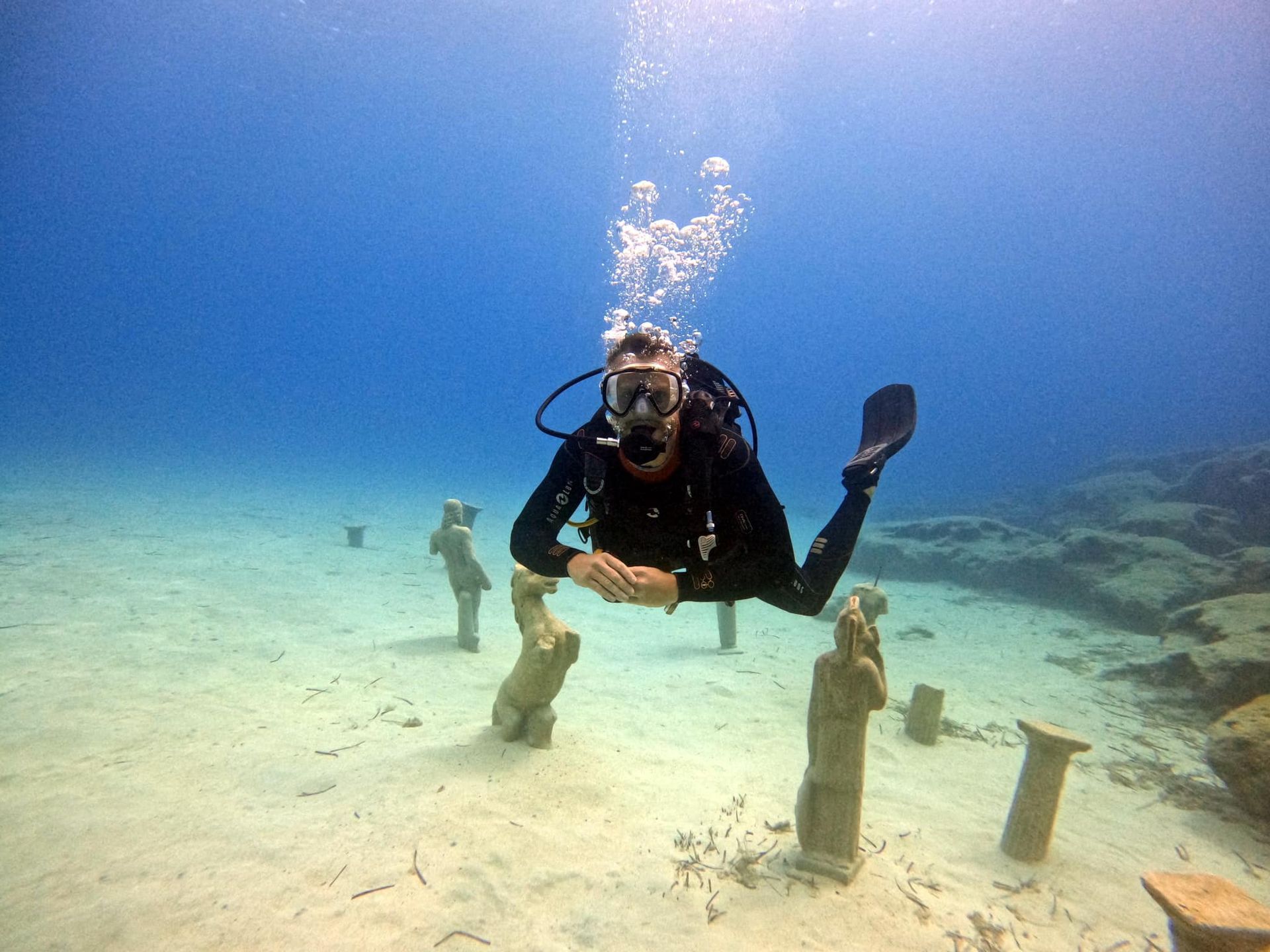 A scuba diver is swimming underwater in the ocean.