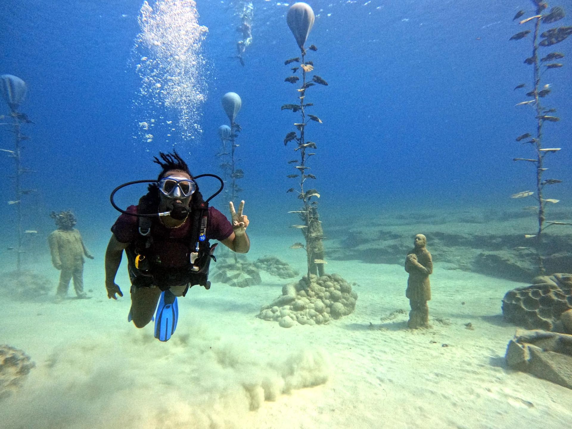A scuba diver is giving a peace sign in the ocean