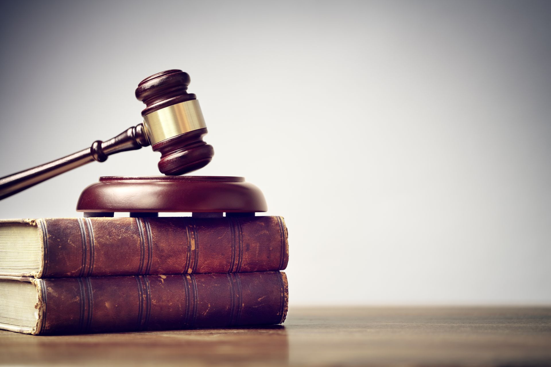 Wooden gavel on top of two aged law books.