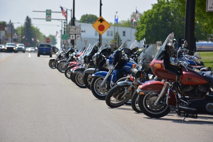 Row of parked motorcycles along a city street on a sunny day