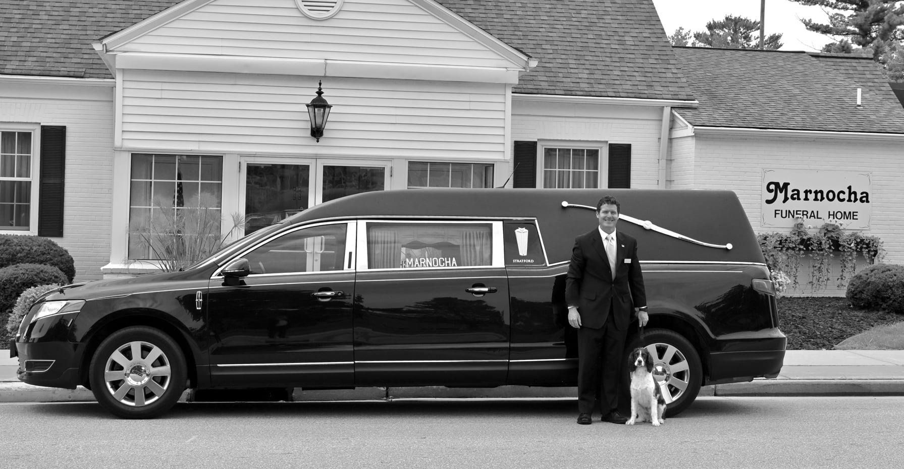 Black SUV parked in front of a building, with a man standing beside it