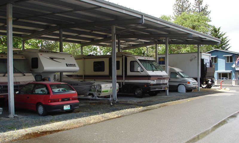 A row of rvs are parked under a covered area