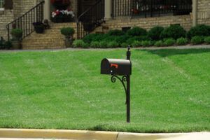 black metal mailbox on green lawn