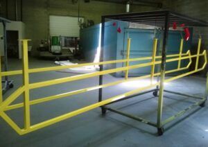 A yellow railing is sitting on a cart in a room.