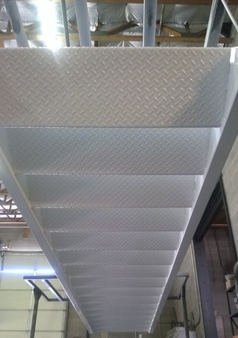 A white metal staircase with a diamond pattern on the steps