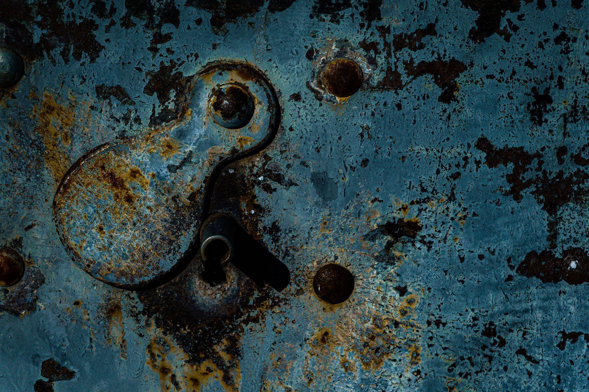 Rusted steel surface with peeling paint that needs sandblasting before it can be coated