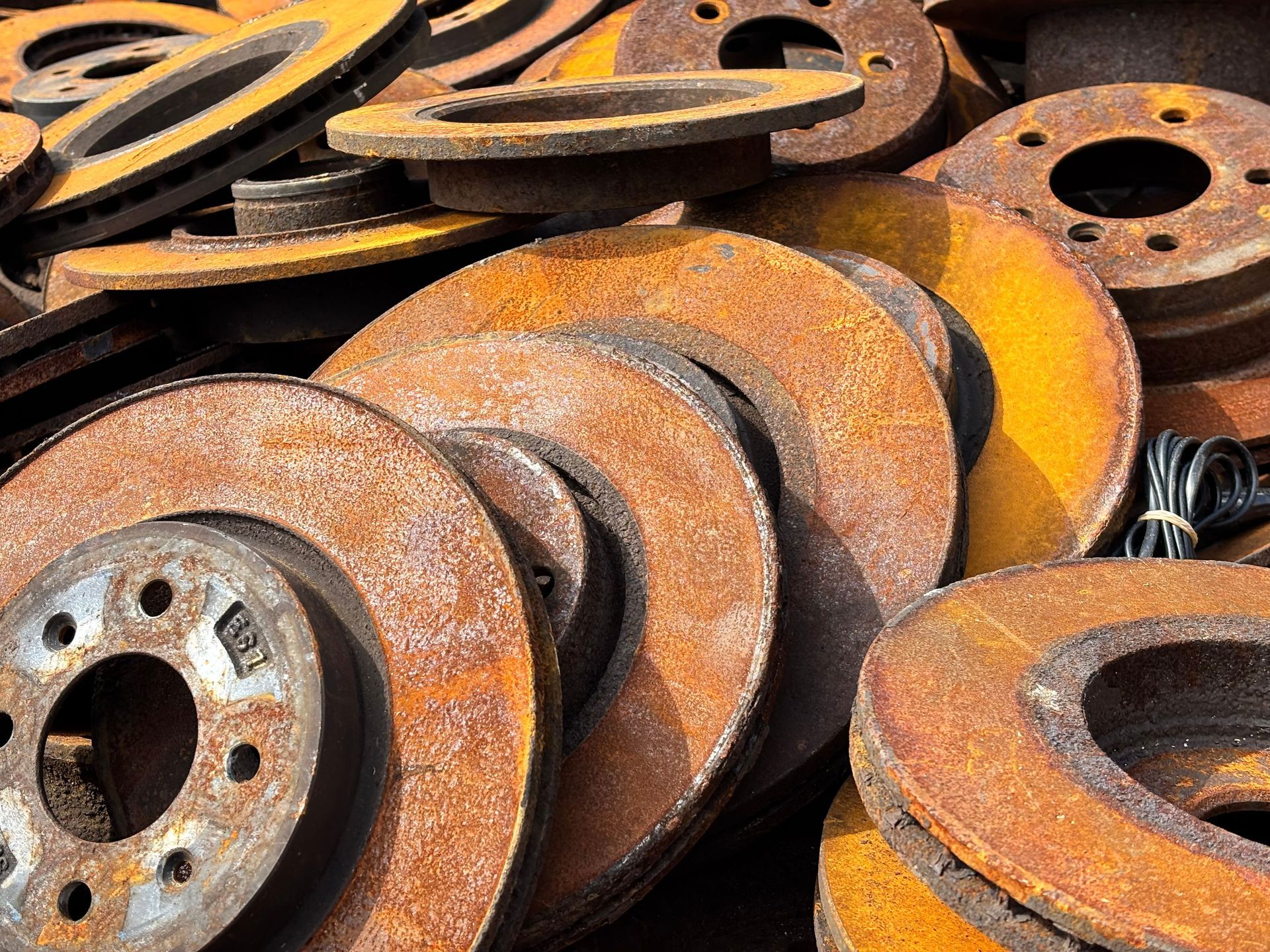 Rusty metal gears and circular machine parts stacked together.