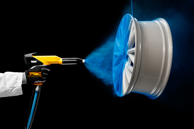 A person is spraying powder paint on a wheel.