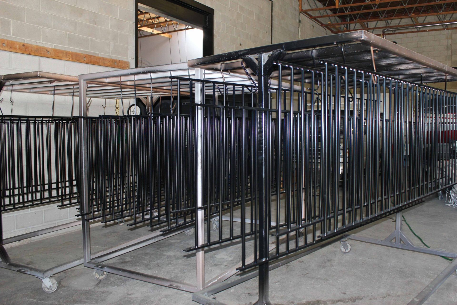 A row of metal fences are sitting in a warehouse.