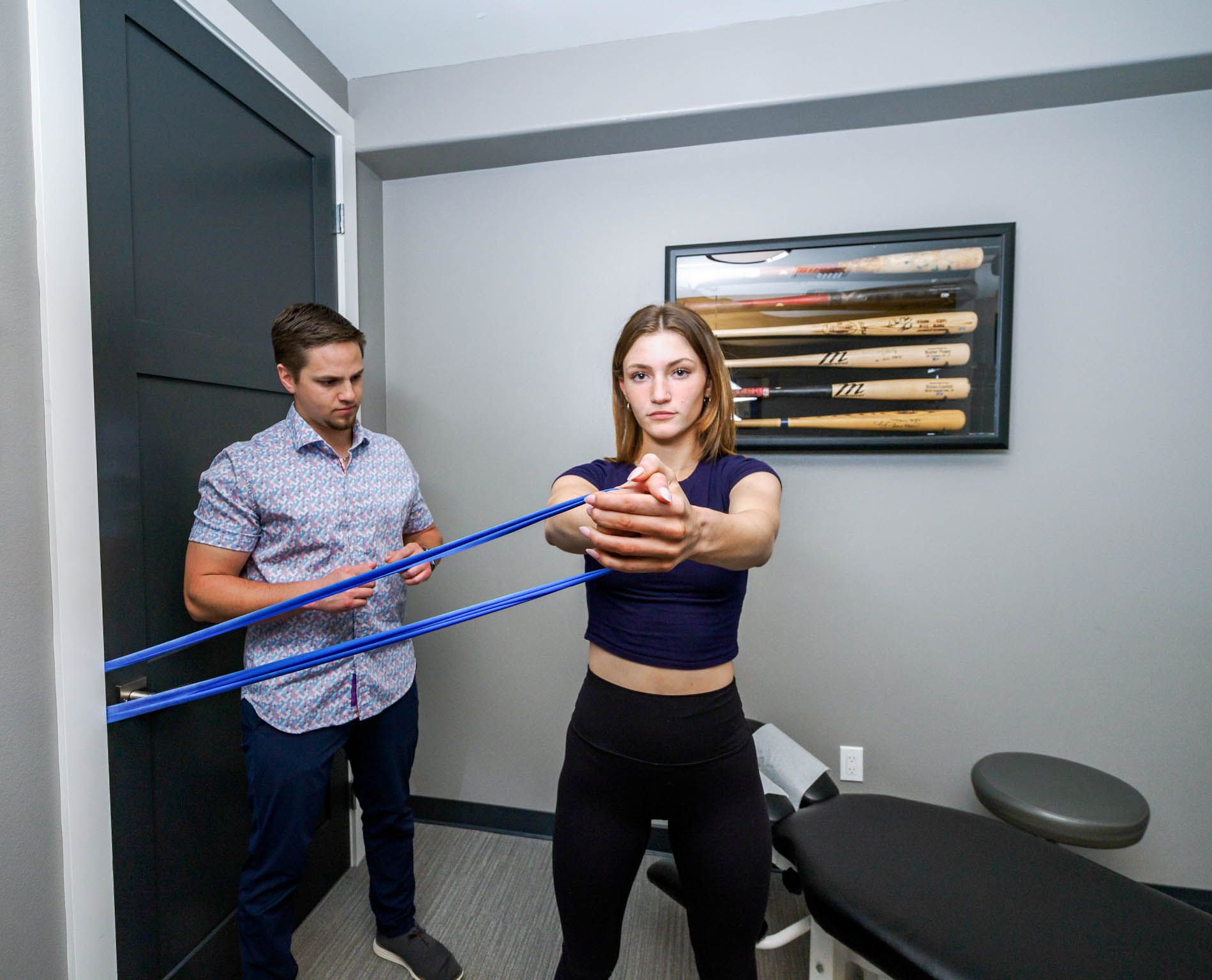 A man and a woman are doing exercises with a resistance band.