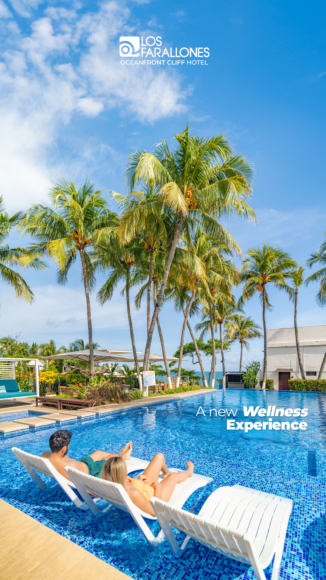 Two people relaxing on floating lounge chairs in a blue resort pool with palm trees and a clear sky