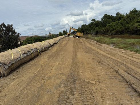 Cleared land with a graded access road and debris pushed to the edge