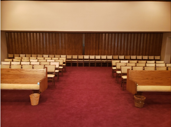 Empty courtroom with wooden benches and red carpet facing the judge’s bench