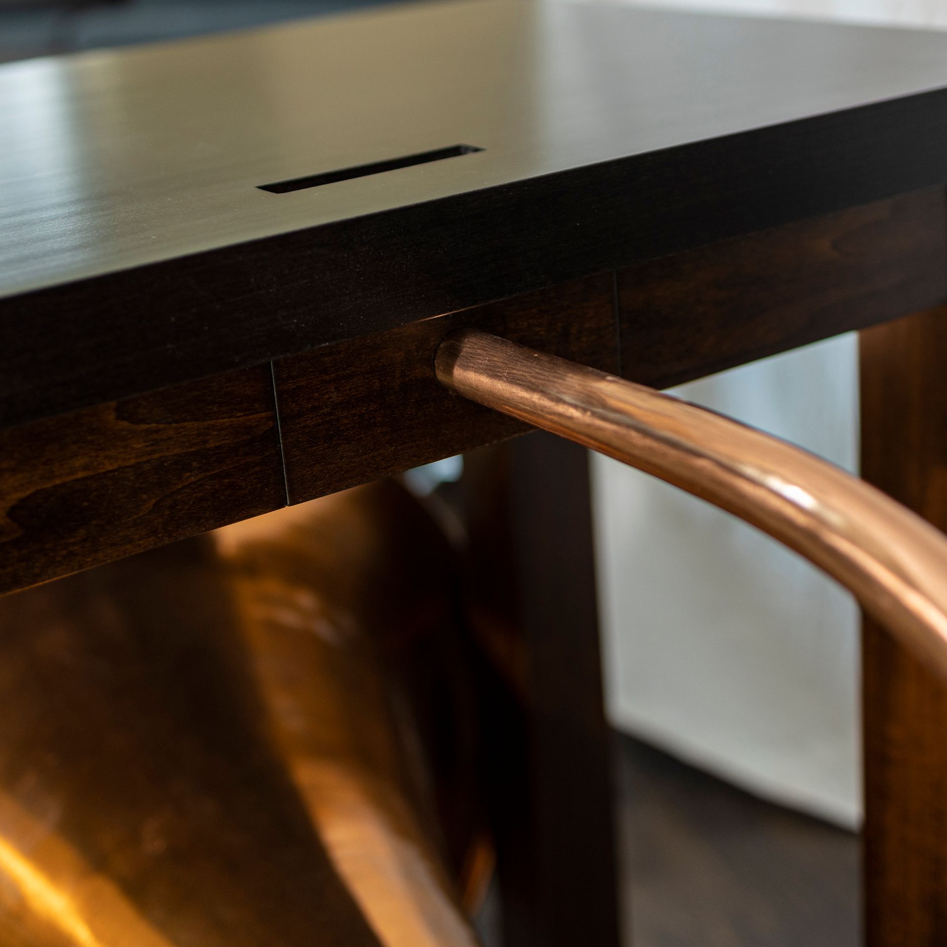 A wooden table with a copper pipe attached to it