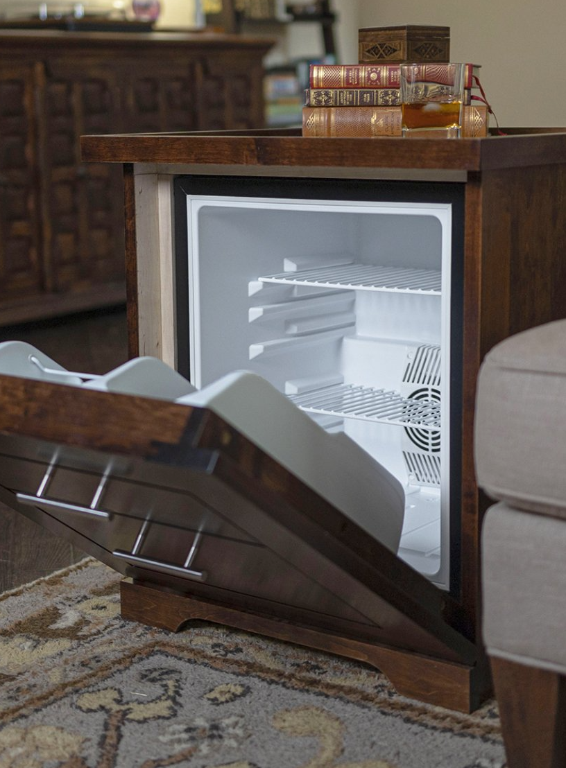 A small refrigerator is open in a living room