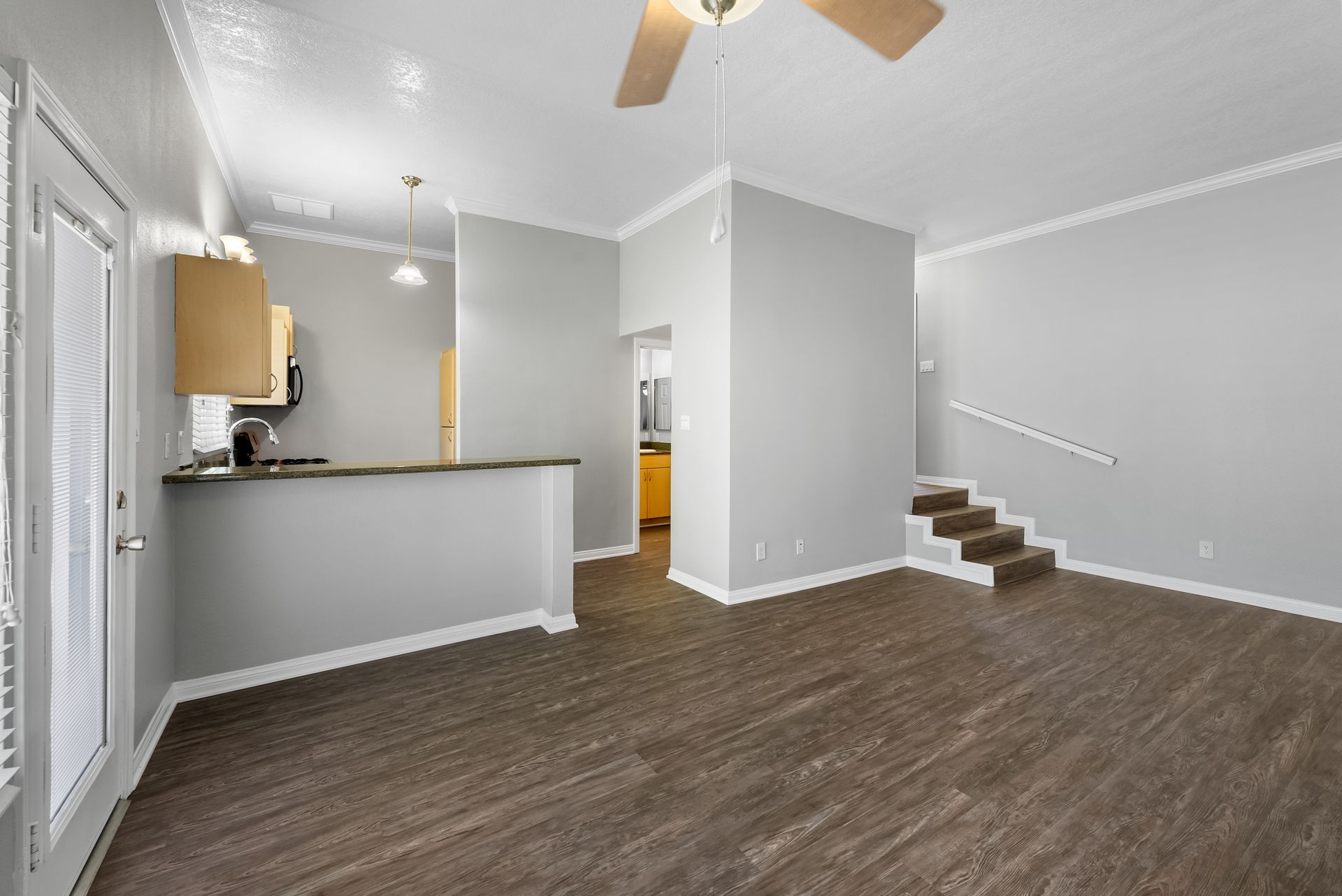 Living room and kitchen with stairs to front door