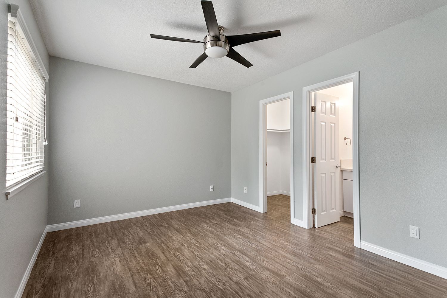 bedroom with fan and walk-in closet and bathroom