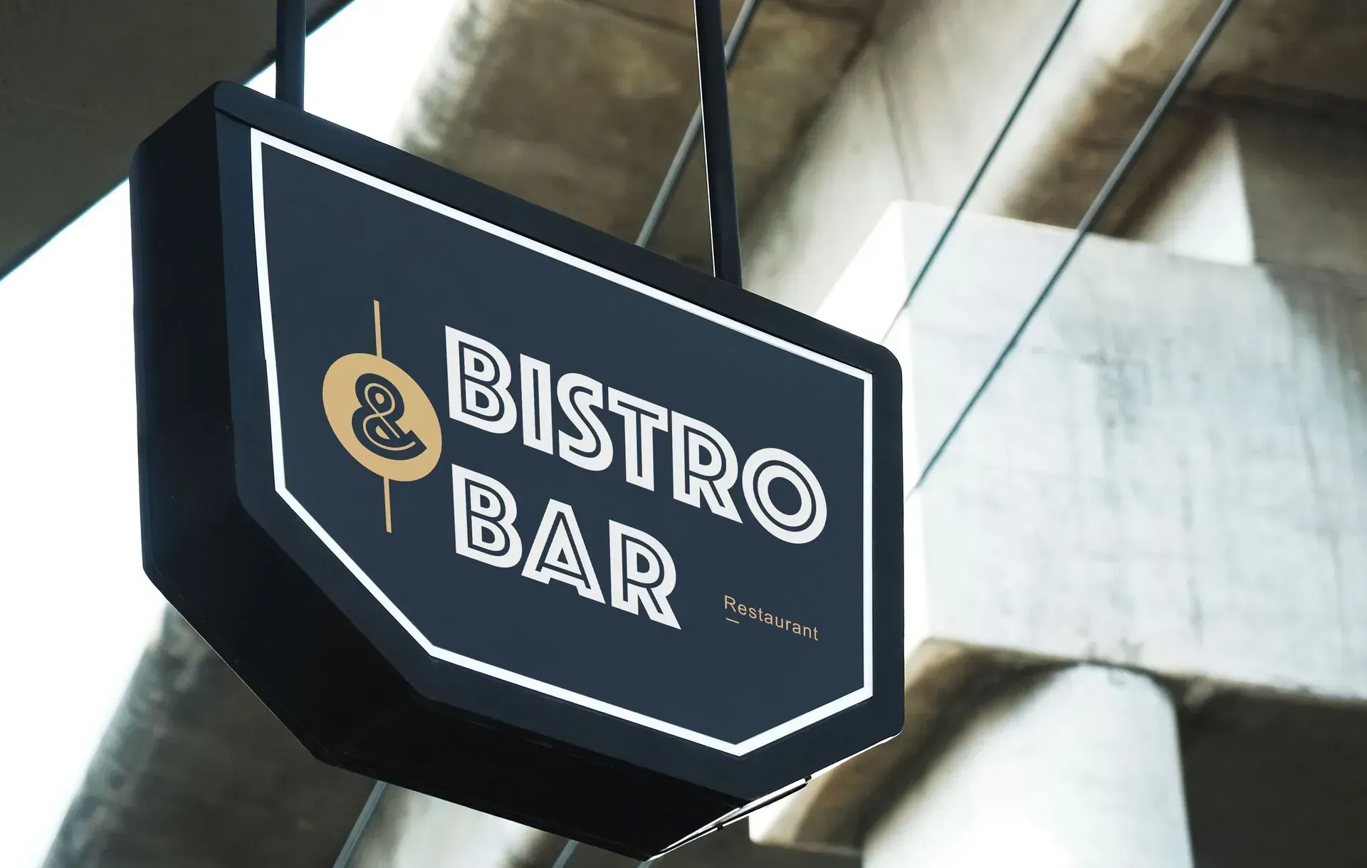 Black hanging sign reading “Bistro Bar” on a building exterior.
