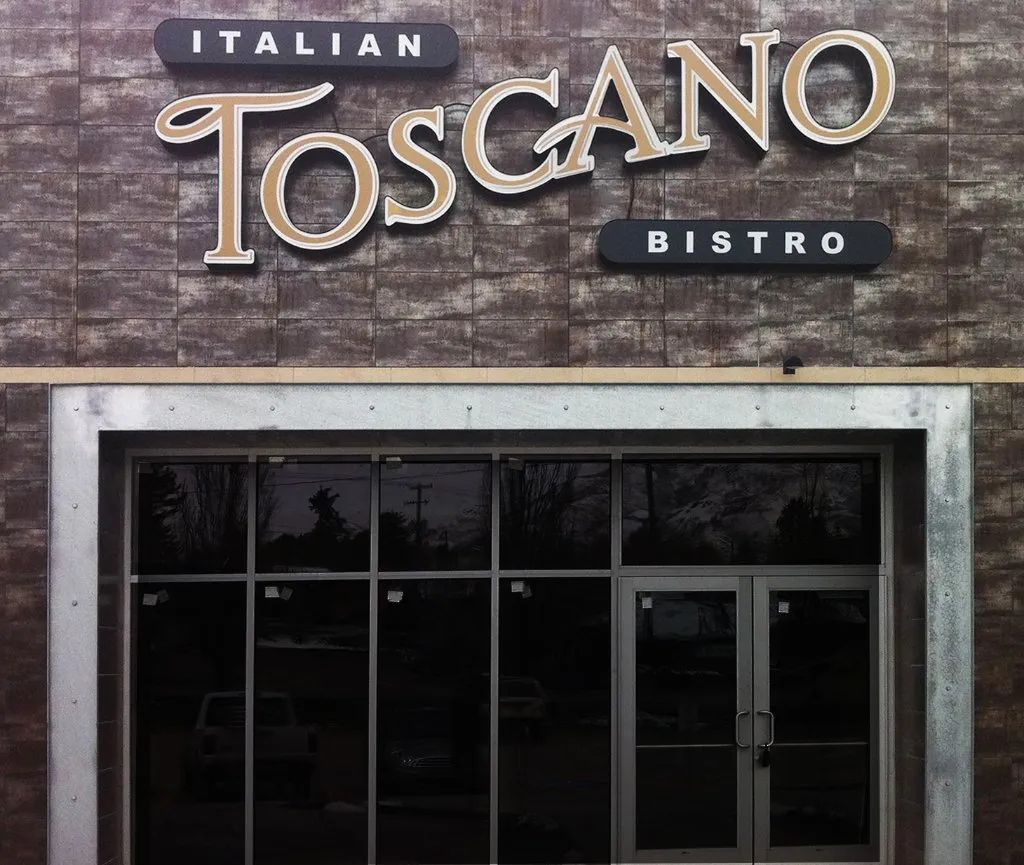 Italian Toscano Bistro sign above a storefront with dark windows and glass doors