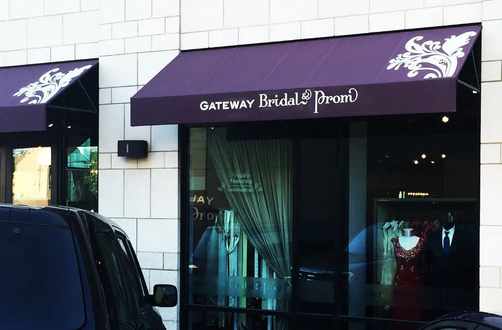Storefront with purple awning for Gateway Bridal & Prom, seen from the street at night