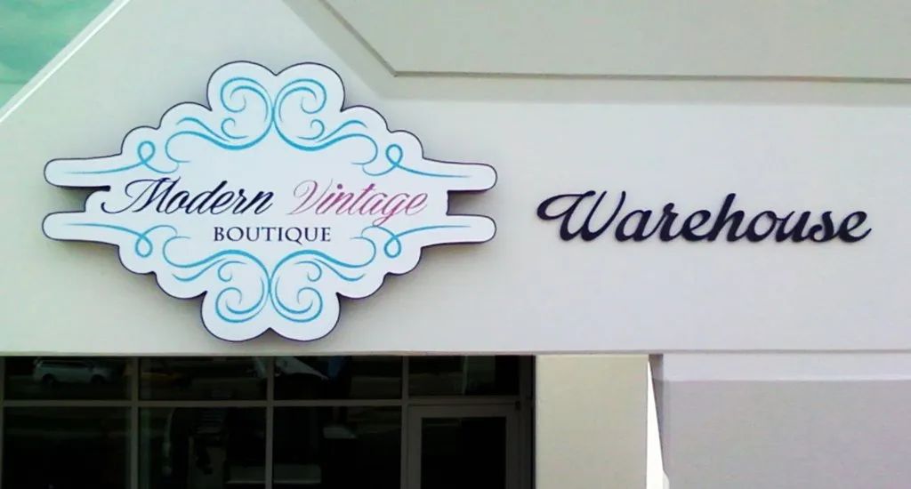 Storefront sign reading “Modern Vintage moments” beside the word “Warehouse” on a white facade
