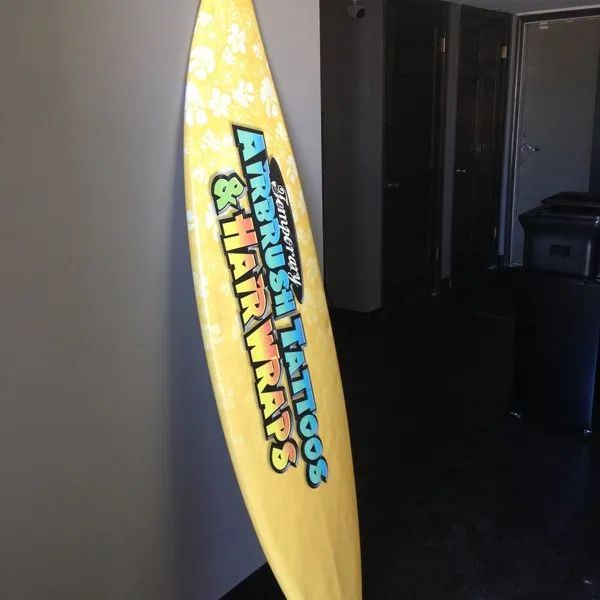 Yellow Star Wars surfboard leaning against a wall indoors.