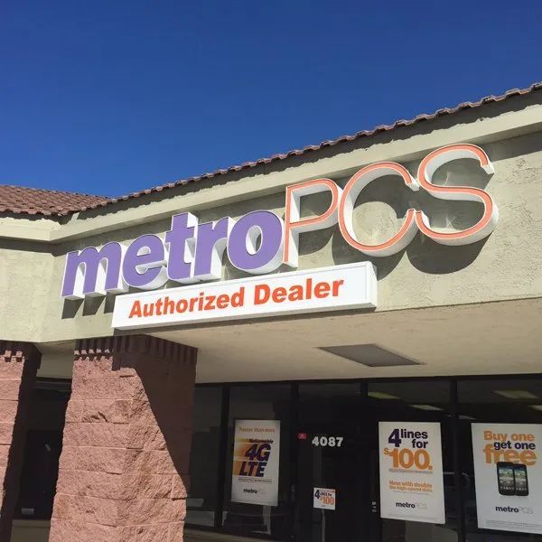 MetroPCS Authorized Dealer storefront with purple and orange sign under a blue sky