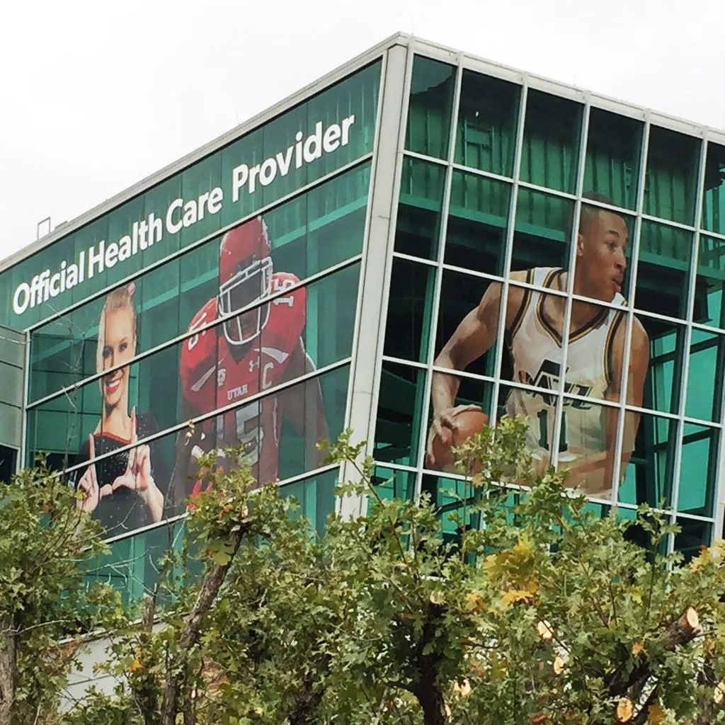Glass-fronted building with large health and fitness advertisements and the words “Official Health Care Provider”