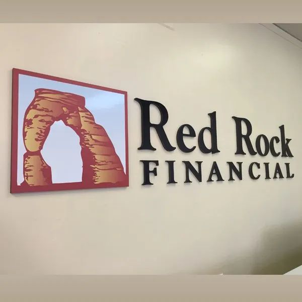 Red Rock Financial logo with red sandstone arch icon and black text on a wall