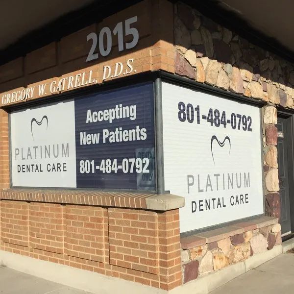 Platinum Dental Care storefront with 2015 sign, accepting new patients and phone number displayed on windows